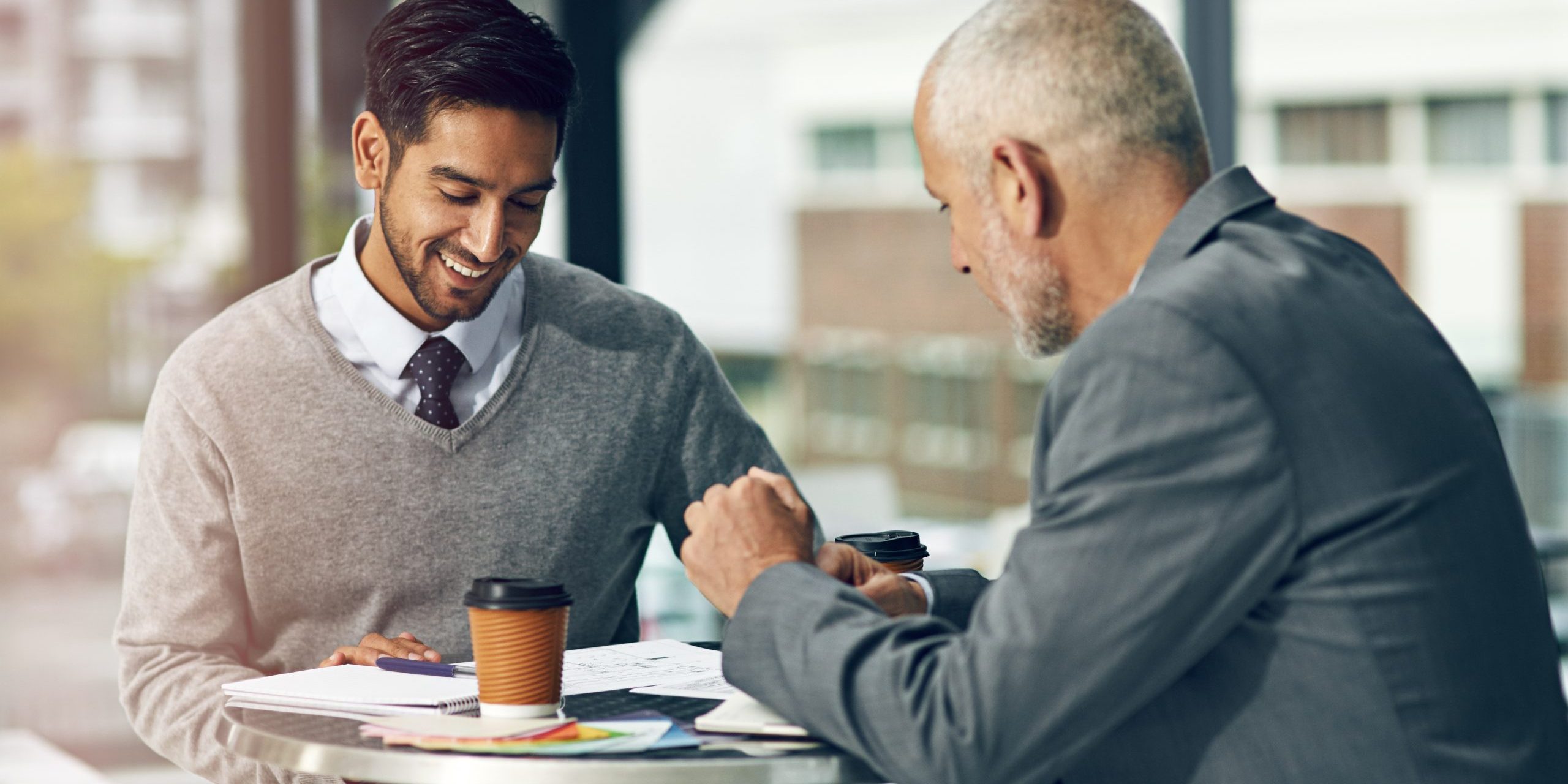 Professional coach guiding employee in a modern office setting, demonstrating effective coaching in the workplace example