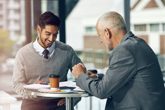 Professional coach guiding employee in a modern office setting, demonstrating effective coaching in the workplace example